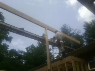 Carpenter setting a ridge beam over a new addition frame in Shaftsbury