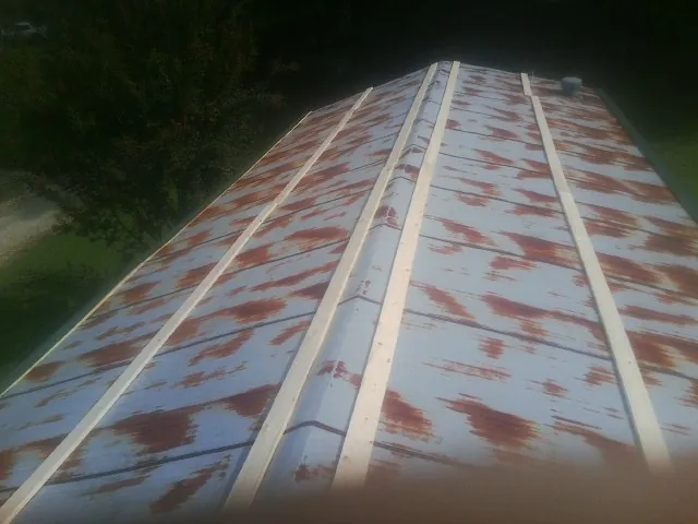 Rusted metal roof panels with new wood purlins before replacement — Storm Damage Roof Repair in Shaftsbury by Roofing Brothers