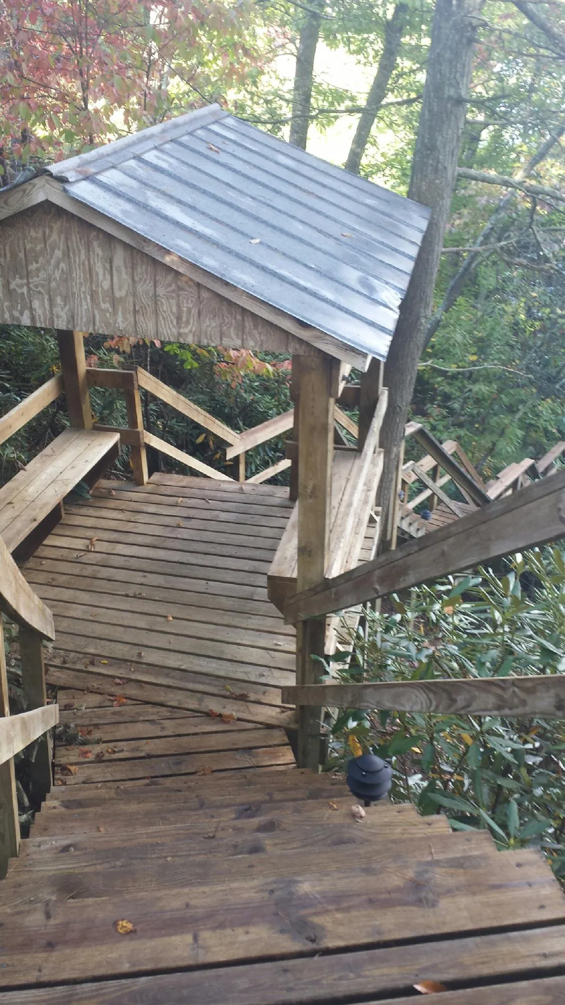 Metal roofed shelter over wooden steps on a wooded walkway — Skylight Repair & Installation work by our crew in Shaftsbury