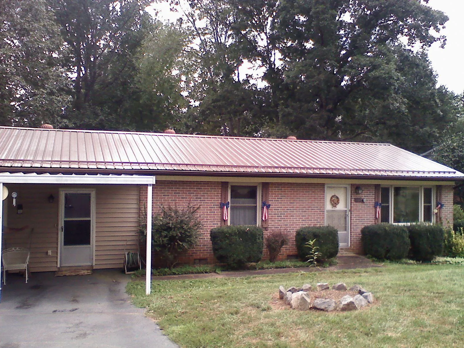 Bronze metal roof and carport on a brick ranch home — Roof Repair work by our crew in Shaftsbury
